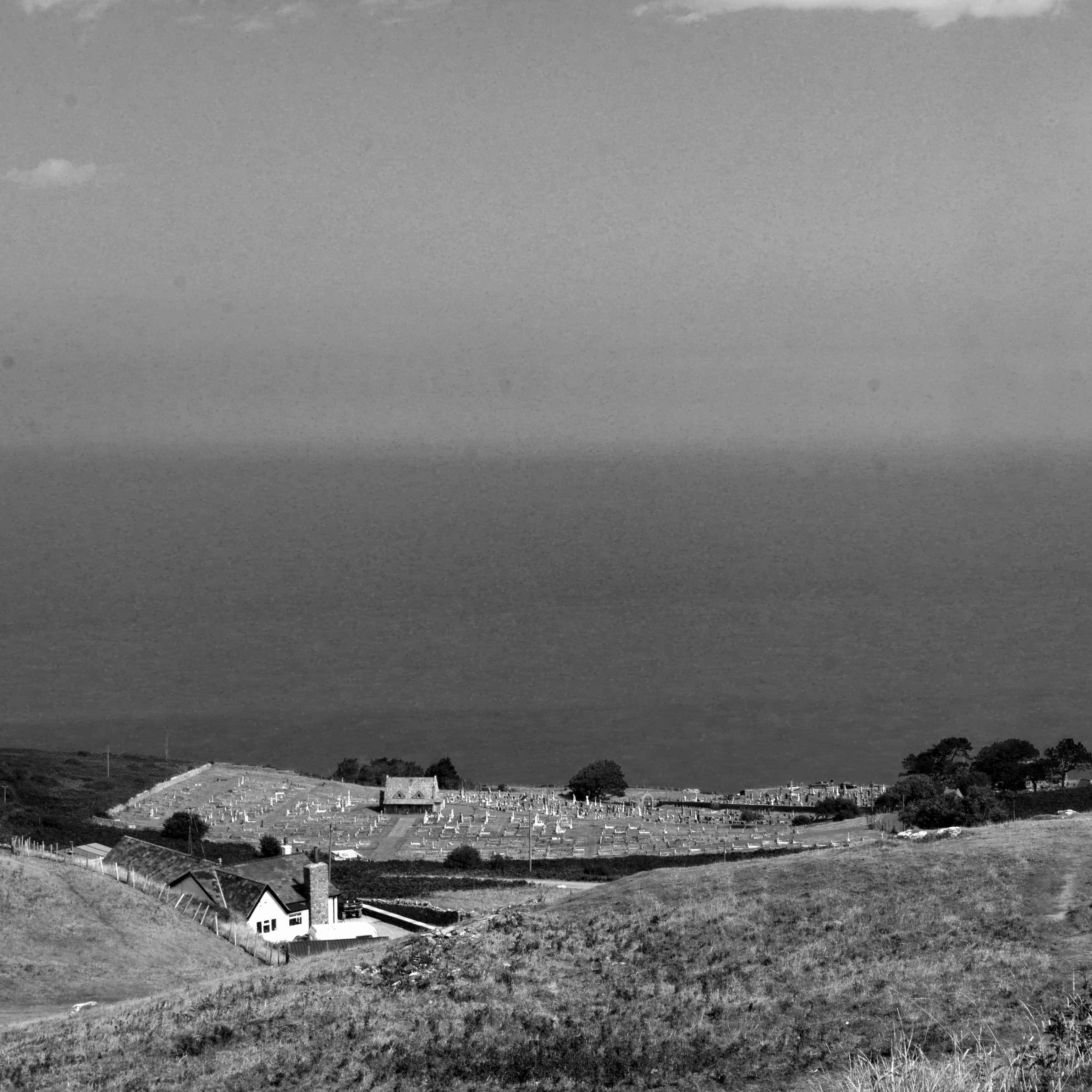 A cemetery as viewed from the top of the Great Orme, with the sea visible behind