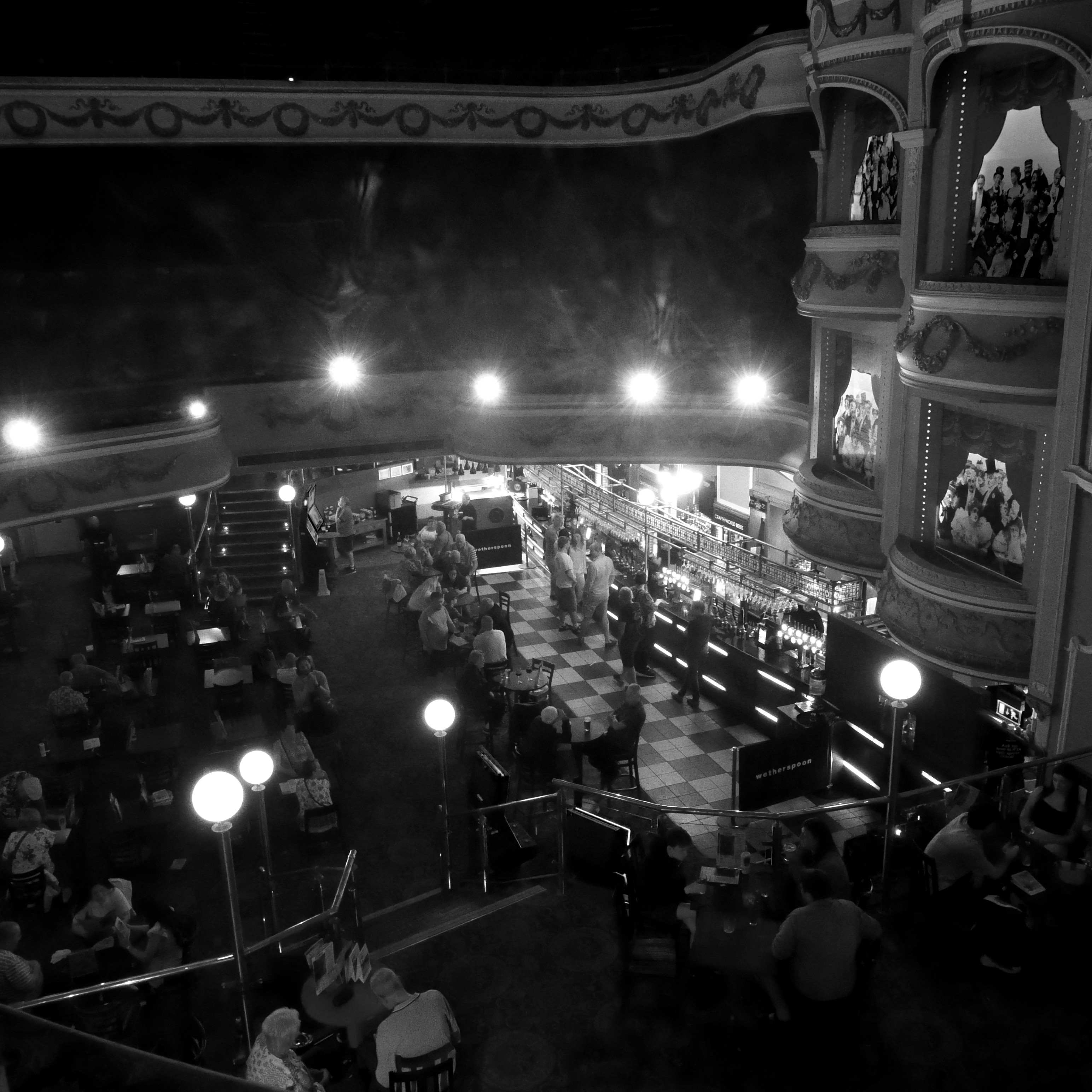 Inside of Wetherspoons, in a converted theatre. The stalls form the main pub area, but upper tiers of seating are still visible. The photo is taken from the perspective of the stage (which now houses the toilets!)
