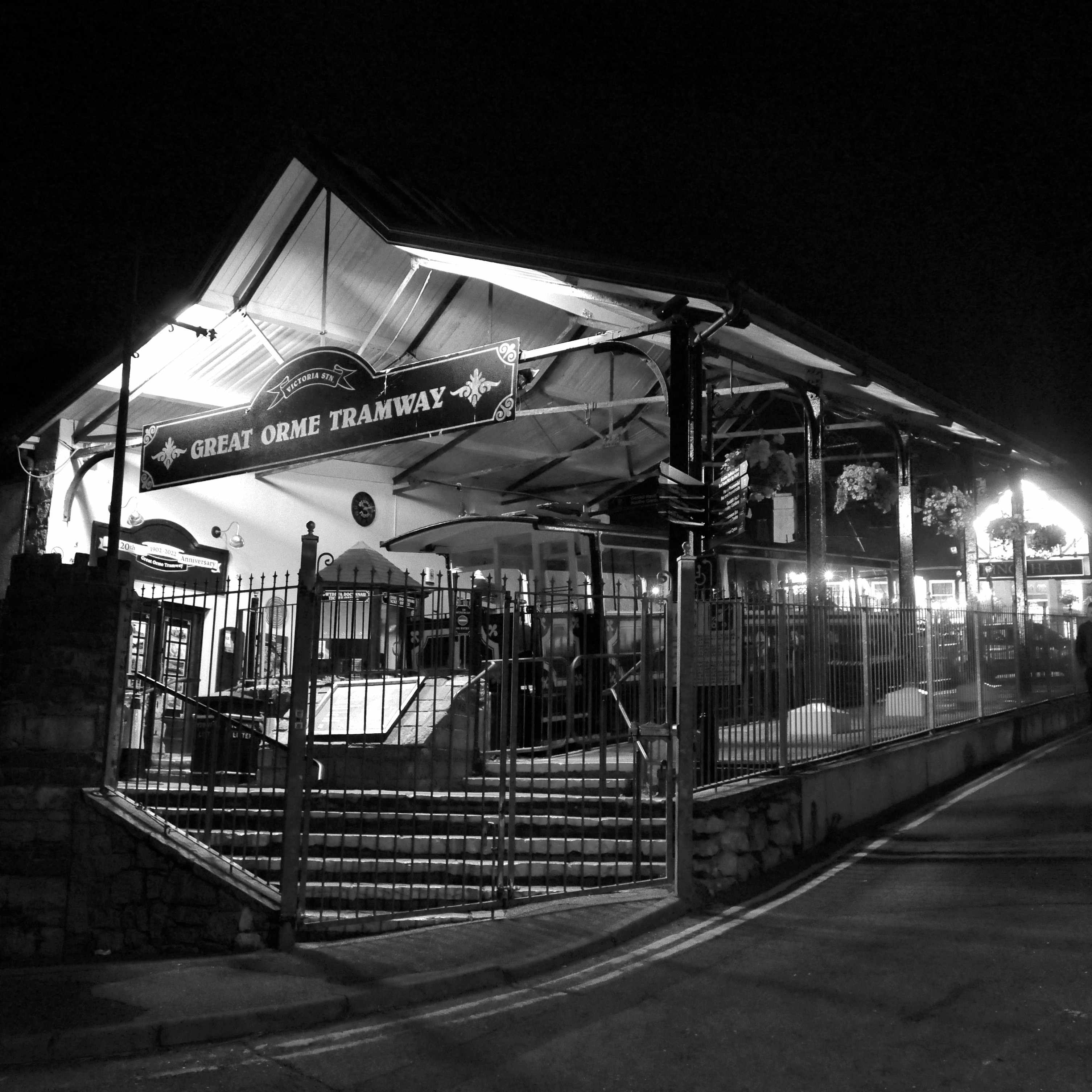 High-contrast image of an illimuinated tram station at night