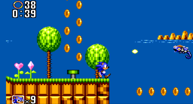 A screenshot of Sonic facing a Meleon enemy, a colum of rings over a spring behind him, in a 'Green Hill Zone'-like environment