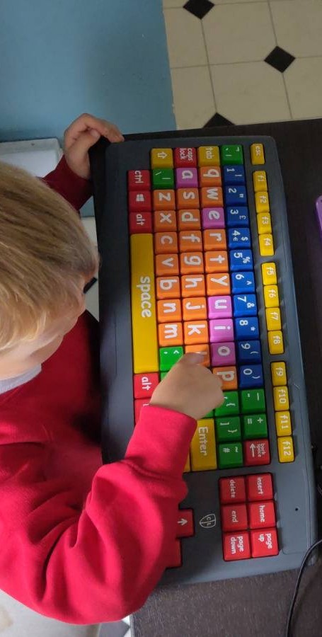 An adorable oversized children's keyboard with different colours for numbers, punctuation, vowels, and consonants.